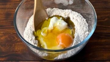 Barley flour, yogurt, olive oil and egg in a bowl.