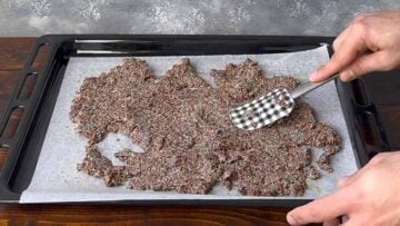 Flaxseed cracker dough on a baking sheet.