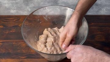 A hand kneading dough.