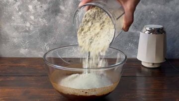 Adding dry milk powder and peanut butter to the cacao mixture.