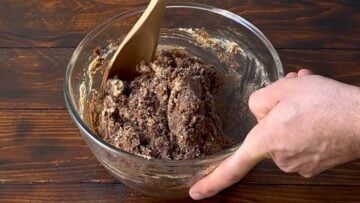 A bowl with the protein bars mixture and a wooden spoon.
