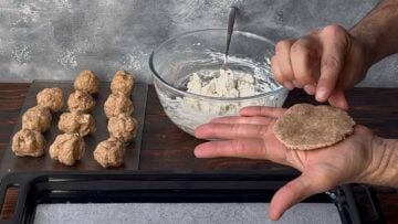 Two hands rolling a piece of dough.