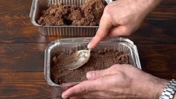 Pressing the protein bars mixture into aluminum pans.