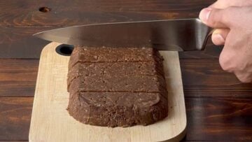 A hand cutting the protein bars.