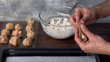 Two hands folding the feta pie.