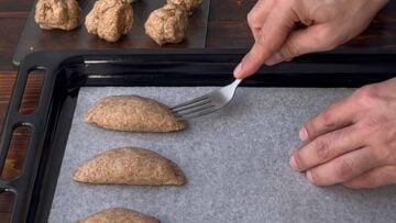 Savory feta pies on a baking sheet and a fork.