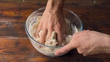 A hand kneading the dough.