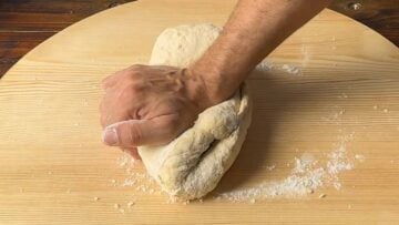 A hand kneading the dough for phyllo.