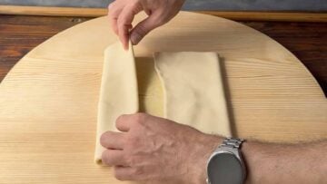 Two hands folding the phyllo again.